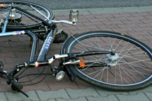 Rowerzystka podczas jazdy na rowerze w kasku ochronnym – bezpieczeństwo na drodze.